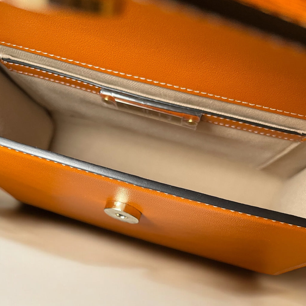 Détail du sac Gabrielle orange – Gros plan sur l'intérieur , la couture et la tranche du cuir
